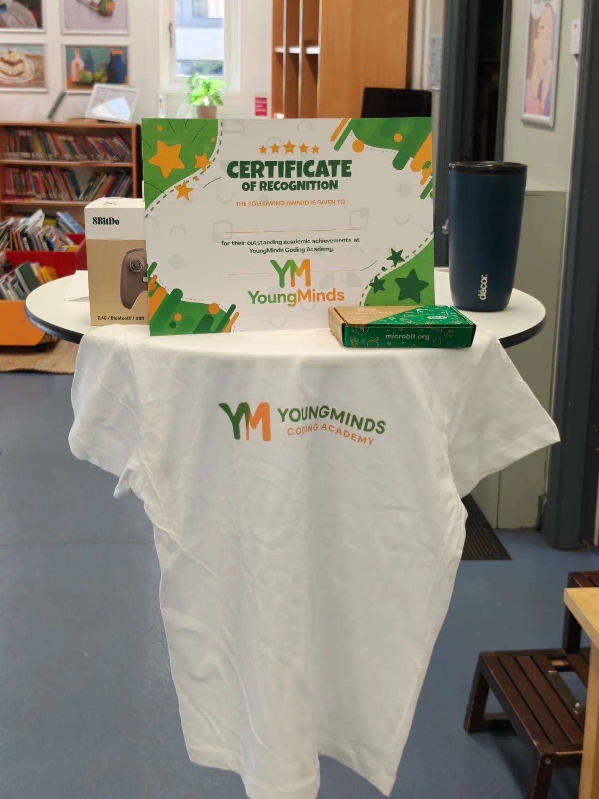 A certificate of recognition, YoungMinds t-shirt and camp kit laid out at the end of the week