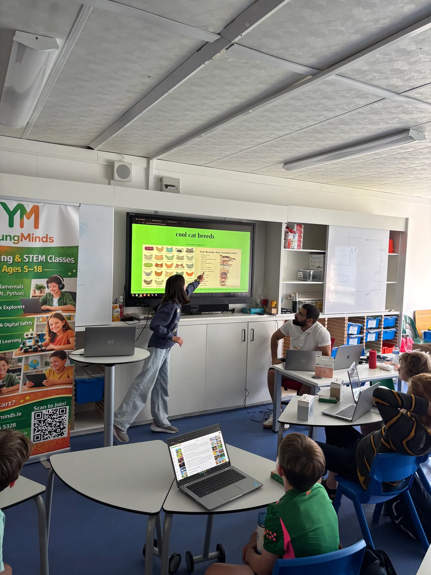 A camper presenting their project on the big screen while the room watches