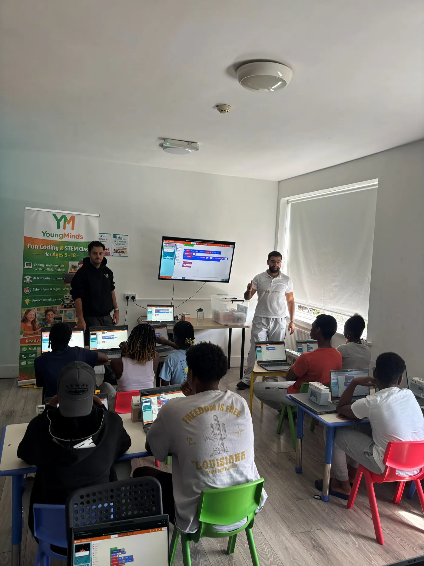 Two mentors teaching a MakeCode lesson at a community coding session