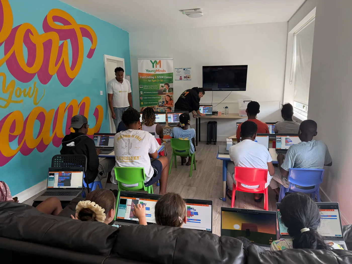 Mentors and students in a colourfully painted community classroom