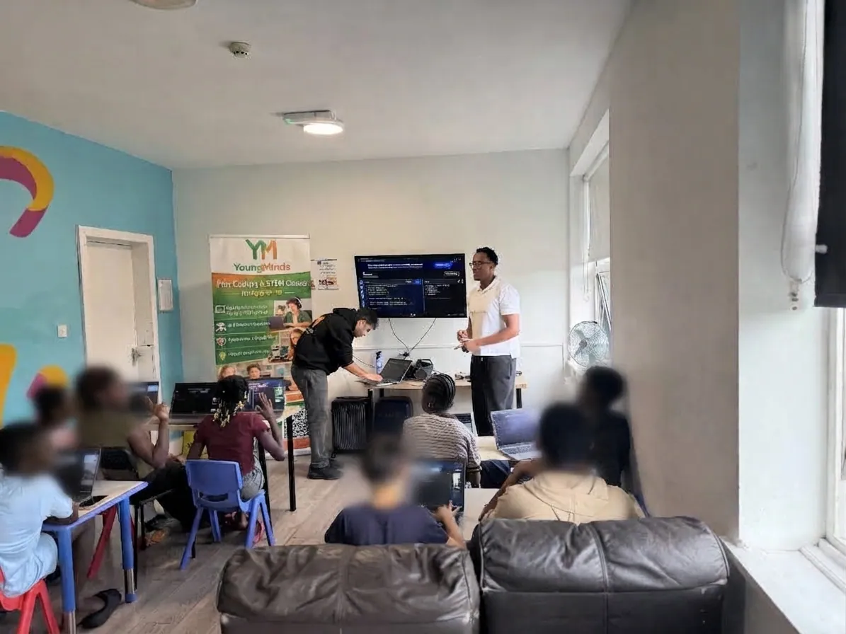 A YoungMinds community digital skills workshop, with mentors and young people around laptops